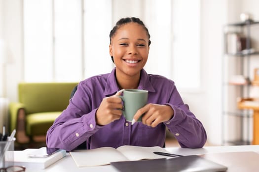 Student enjoying cup of coffee while studying at home