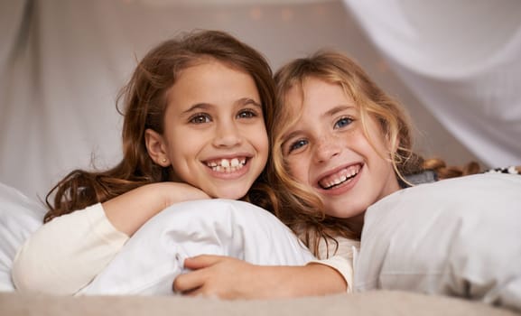 Happy, home and portrait of children in bedroom for playing, bonding and relax with pillow. Sleepover, friends and young girls on bed with smile, happiness and excited for childhood, fun and laughing