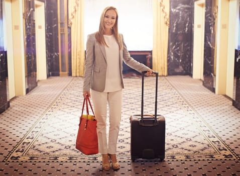 Business woman, luggage and happy in hotel hallway for portrait with suit, handbag and pride in lobby. Person, entrepreneur and smile for international travel with baggage in corridor in New York.