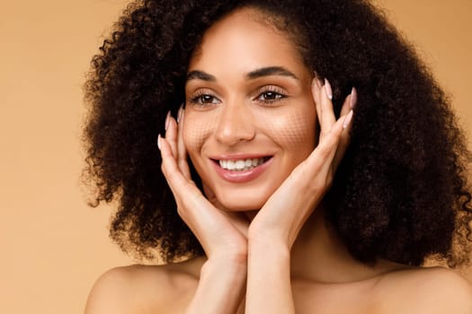 Smiling black woman with bushy hair touching her pretty face
