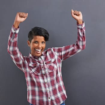 Excited woman, portrait and dancing with fashion for winning or celebration on a gray studio background. Happy female person, Indian or model with smile for success, style or clothing on mockup space