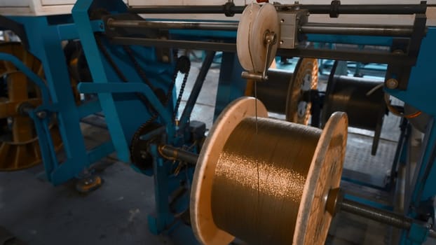 Industrial Machine for winding copper wire on coils. Creative. Automated production of metallurgical plant with swirling copper wires. Winding of copper wire on bobbins of industrial machine