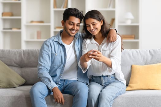 Indian couple enjoying time together looking at smartphone