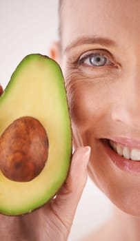 Skincare, avocado and closeup portrait of woman in studio for health, wellness or natural face routine. Smile, beauty or mature person with organic fruit for dermatology treatment by white background.