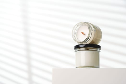 Candle With Extinguished Flame Resting on Glass Jar Near Blinds
