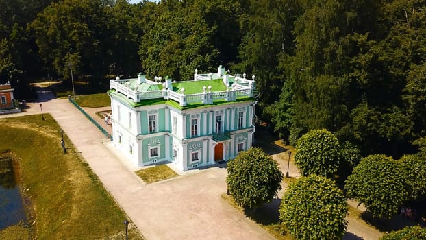 Top view of historic building with garden and pond. Creative. Beautiful park and garden with Baroque estate. Tourists walk in historical park with ancient building