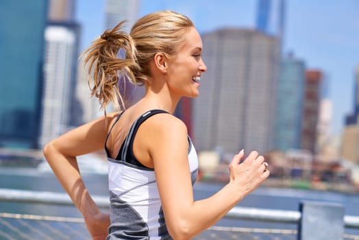 Woman, excited and running for fitness in city, jogging active and fit female person exercising in New York. Energy, marathon for sports training and workout for athlete, cardio wellness or endurance