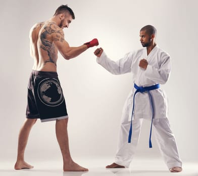 Karate, mma and men fight in competition, exercise or training body in studio isolated on a white background. Sports, martial arts and people sparring in battle for challenge or workout for fitness
