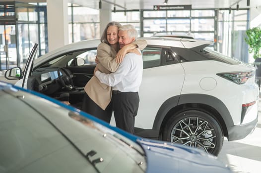 Mature Caucasian couple hugging. Elderly man and woman buying a new car.