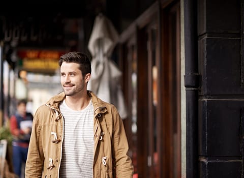 Man, face and happiness in city with fashion by restaurant with urban style, trendy outfit and confidence. Male person, smile and relax outdoor in town with walking, casual clothes and morning trip.