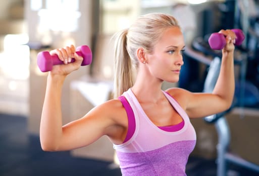 Dumbbells, fitness and woman in gym with arm workout for challenge, health and muscle strength. Weights, exercise and young female athlete with weightlifting training with equipment in sports center.