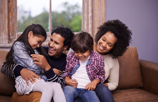 Parents, children and laughing on couch for playing connection for relax holiday, love or bonding. Man, woman and siblings for childhood trust for parenting support or comfort care, joke or happiness