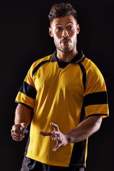 Face, referee or man with warning, foul call or penalty review in sports, rugby or football game at night. Soccer match, dark or person in studio with discipline, rules or caution on black background