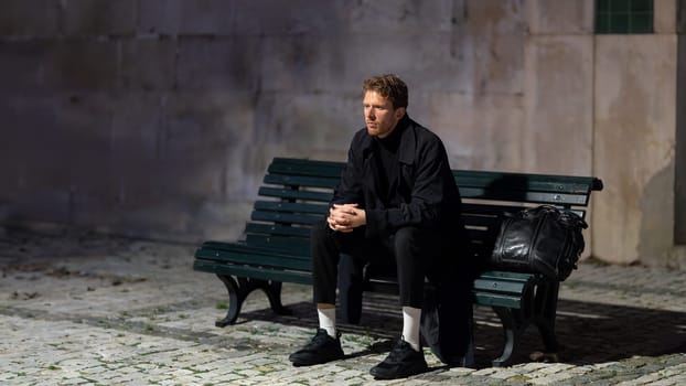 A man sits on a bench in the dark