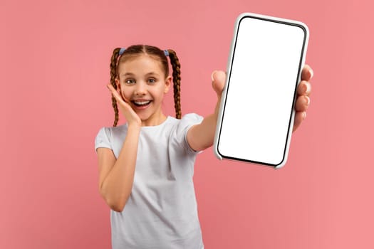 Young girl showing smartphone screen, smiling