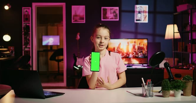 Cute kid filming internet show, promoting green screen tablet received from sponsoring brand