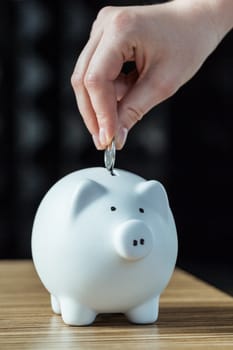 Inserting a coin into a piggy bank