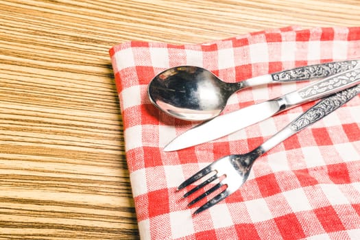 Fork and table knife on red gingham tablecloth