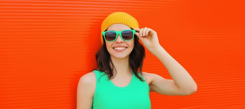 Summer portrait of happy smiling brunette young woman posing in yellow hat, green sunglasses