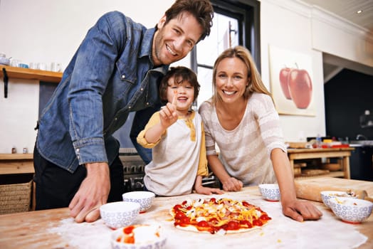 Portrait, family and baking pizza in kitchen together, counter and pastry or sauce for Italian food for summer. Smile, parents and children helping or support in preparation process in home for fun
