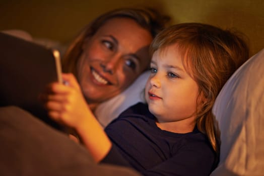 Night, mother or kid with tablet for streaming, playing games or watching videos on movie website in home. Social media, child or happy mom with smile or technology to download on ebook online in bed.