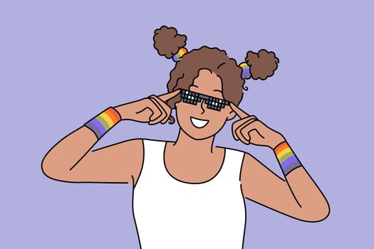 Woman with LGBT bracelets adjusts sunglasses and smiles, drawing attention to LGBTq community