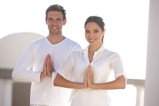 Portrait, man and woman in prayer pose at yoga retreat with smile, peace and relax in mindfulness at outdoor resort. Zen, calm and couple in holistic health, spiritual wellness and namaste with hands.