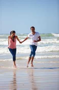 Love, holding hands and couple at the beach running for adventure, fun or bonding in nature. Ocean, water and people at sea with energy, freedom or romance on travel, journey or vacation in Florida