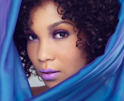 Makeup, beauty and portrait of female person, material or scarf around face for cosmetics. Lipstick, studio and drape for African woman model with closeup, curly and hair for self care and skincare