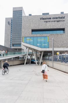 Ghent,Belgium,May 5, 2022: Virginie Loveling Building,Flemish Civic Center,Modern city,girl walks towards the building