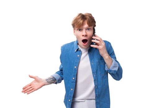 young red-haired guy indignantly listens attentively to the interlocutor on the phone