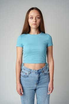 Young woman in blue t-shirt looking at camera with serious expression