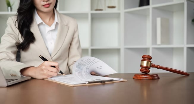 A female Asian lawyer reviews business and real estate laws. Legal consultants provide legal advice and guidance online via laptops in lawyers' offices.