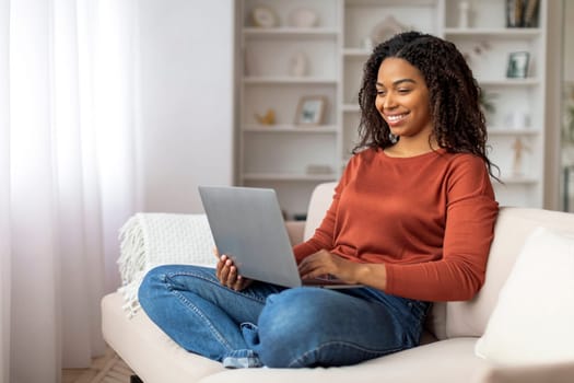 Black Woman Sitting on Couch Using Laptop Computer