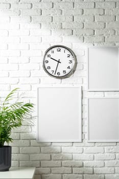 Minimalist White Wall Display With Clock and Empty Frames in a Modern Interior