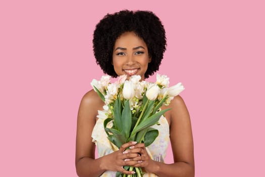 Smiling African American woman holding white flowers
