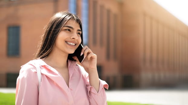 Smiling student on a phone call in sunshine