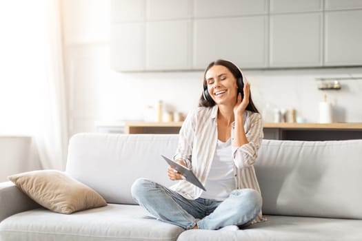 Woman enjoying music with tablet at home