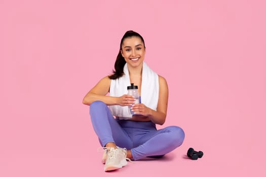 Fitness enthusiast sitting with water bottle