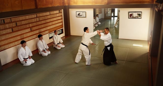 Japanese men, martial arts class or training in fight, modern or aikido to learn self defence. Sensei, black belt students and instruction in dojo place, sport and combat demonstration for discipline