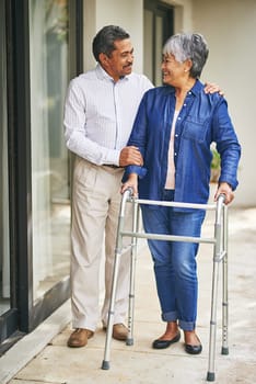 Couple, happy man and senior woman with walker in backyard for care, love or bonding. Retirement, male pensioner and elderly female person with disability for support, embrace or morning walk.