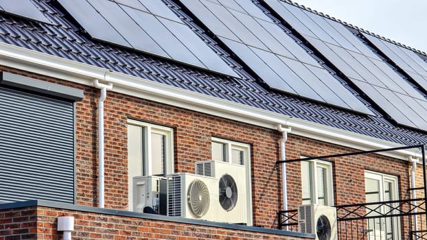 air source heat pump unit installed outdoors at a modern home with solar panels in the Netherlands