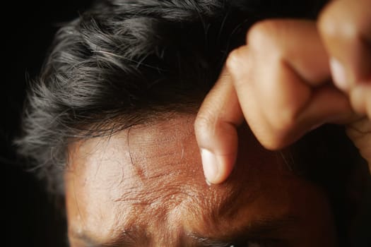closeup of sweat on forehead against dark background ,