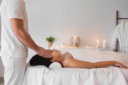 Woman receiving head massage in modern spa