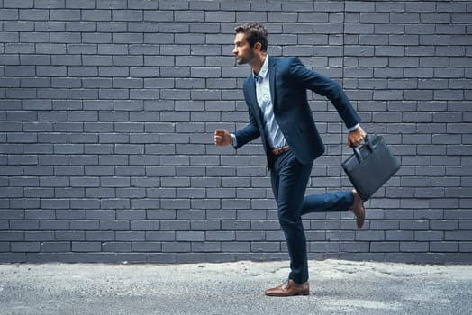 Rush, man and suit in city for corporate career, professional business or company with briefcase. Young person, run and handsome with formal wear for organisation or hurry in urban brick wall mockup