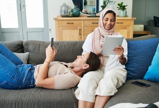 Muslim, woman and friends on couch, technology and relax, game and app in phone, tablet and home. House, lounge and female person with hijab, digital and mobile for texting, communication and website.