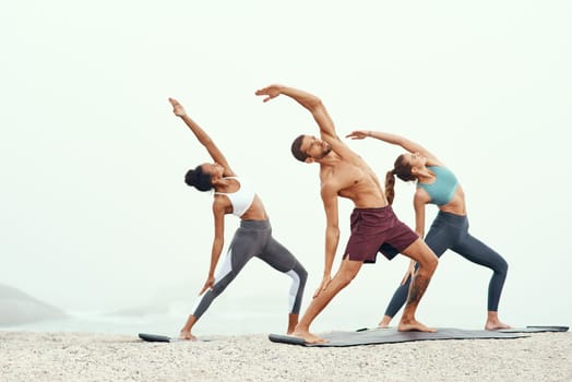 Men, woman and yoga on beach with stretching balance or mindfulness with chakra, wellness or friends. People, arms and morning mist at ocean or pilates warm up for calm self care, exercise or group.