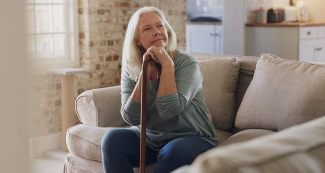 Senior woman, thinking and walking stick for balance in home, recovery and memory or relax on sofa. Retirement, wonder and person with disability on couch, arthritis and cane for assistance or help