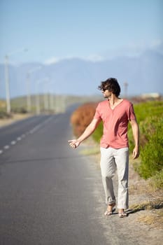 Man, hitchhiking and hand sign for taxi on road trip or travel journey and adventure in summer. Tourist, person or explorer outdoor on highway hailing for cars, drivers and lift on vacation walking.