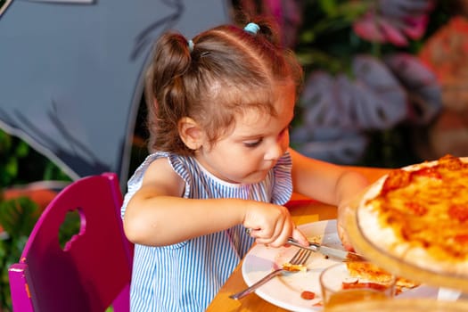 Young Girl Enjoying a Slice of Pizza at a Birthday Party Indoors